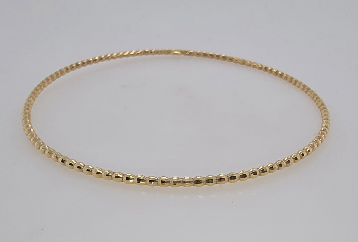 9CT YELLOW GOLD HOLLOW BEAD BANGLE 1.8MM X 65MM 2.2GRAMS.