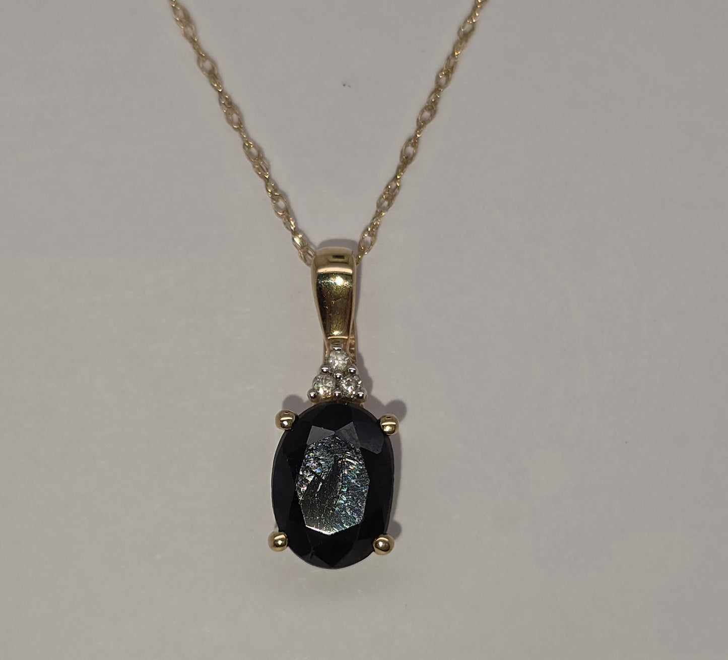 9CT YELLOW GOLD 8 X 6 OVAL SAPPHIRE AND DIAMOND PENDANT.