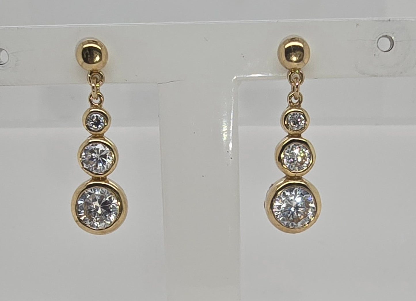 9CT YELLOW GOLD BEZEL SET DROP CUBIC ZIRCONIA STUD EARRINGS.