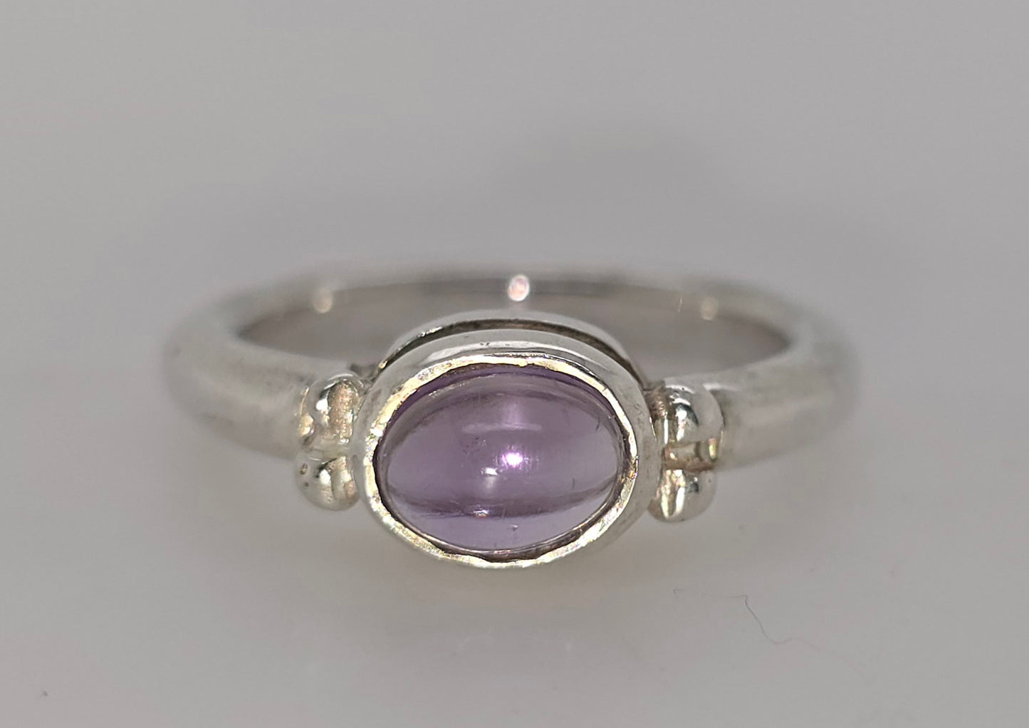 STERLING SILVER BEZEL SET 7 X 5MM AMETHYST CABOCHON FANCY RING.