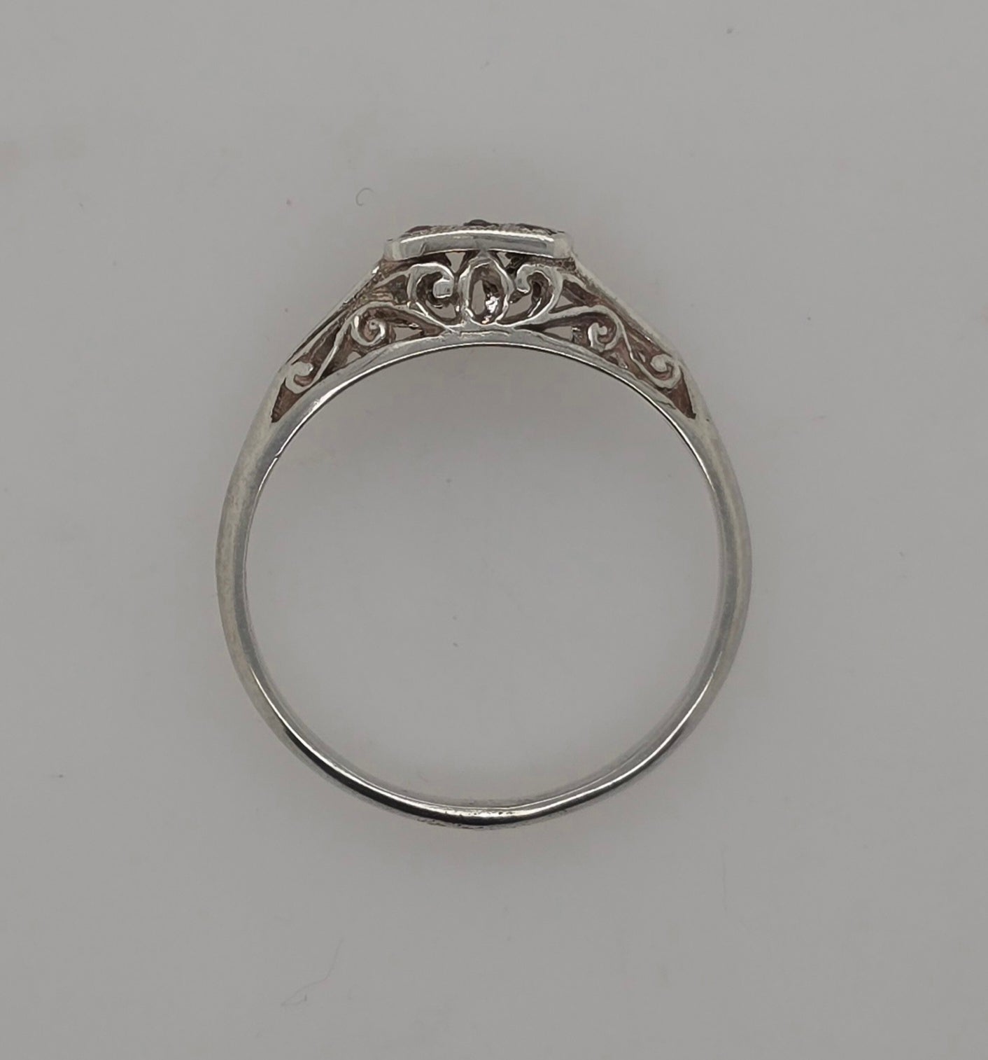 STERLING SILVER GARNET RING WITH FILIGREE SIDES.