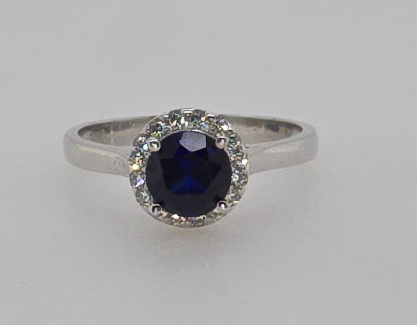 9CT WHITE GOLD AND CR. BLUE SAPPHIRE CUBIC ZIRCONIA HALO RING