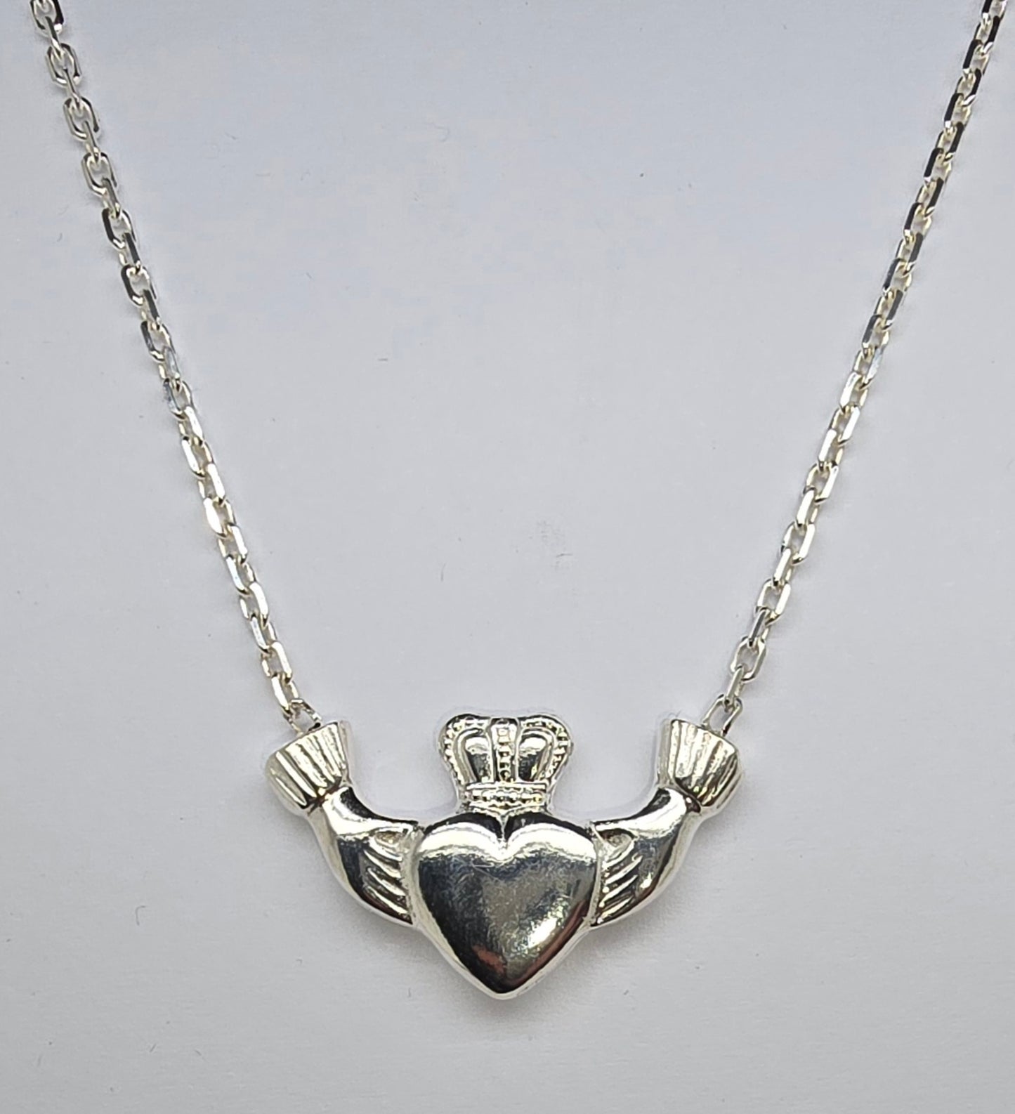 STERLING SILVER SOLID CLADDAGH PENDANT WITH ATTACHED CABLE CHAIN.
