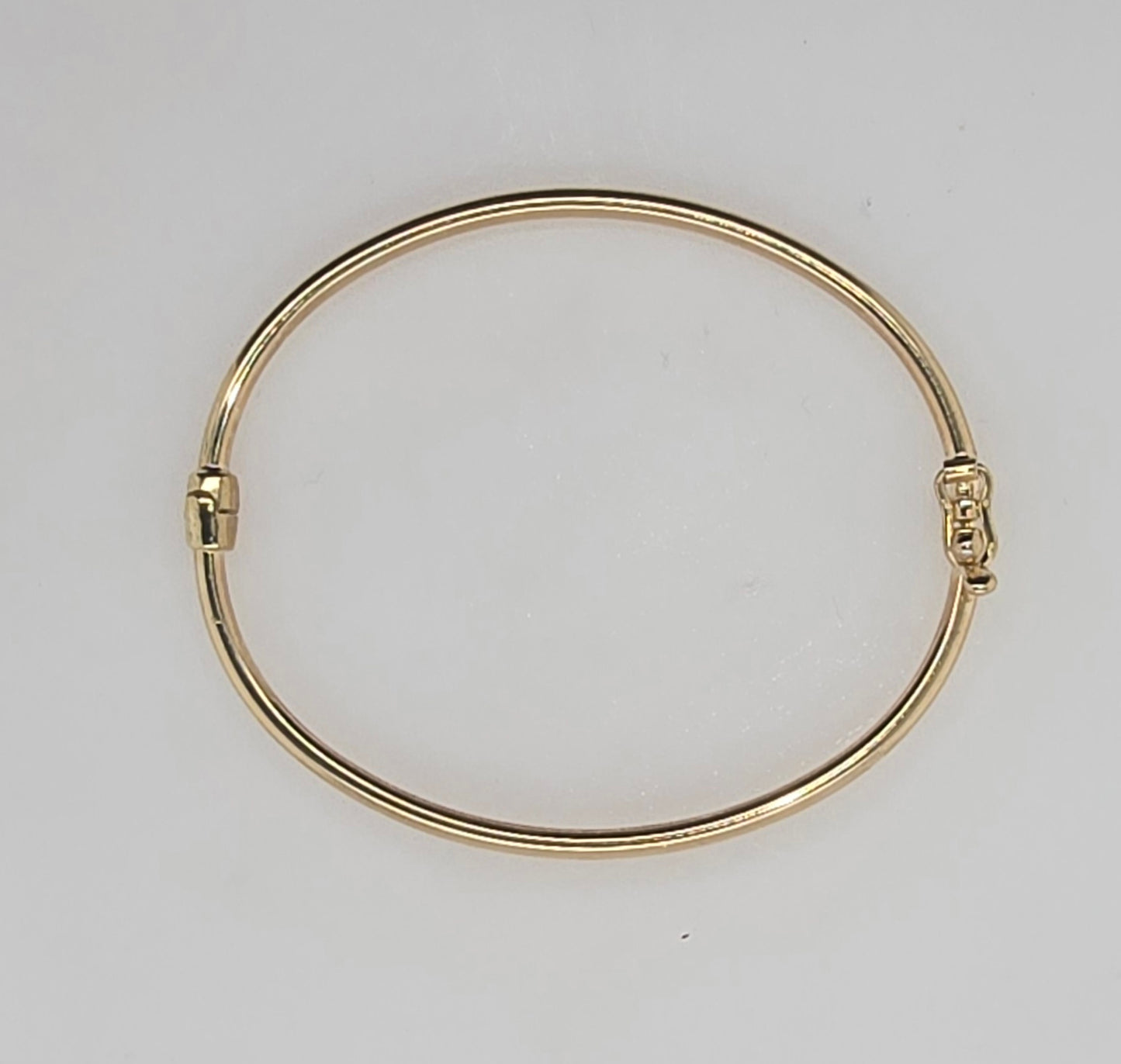9CT YELLOW GOLD 2MM X 45MM X 38MM OVAL HINGED GOLF BANGLE.