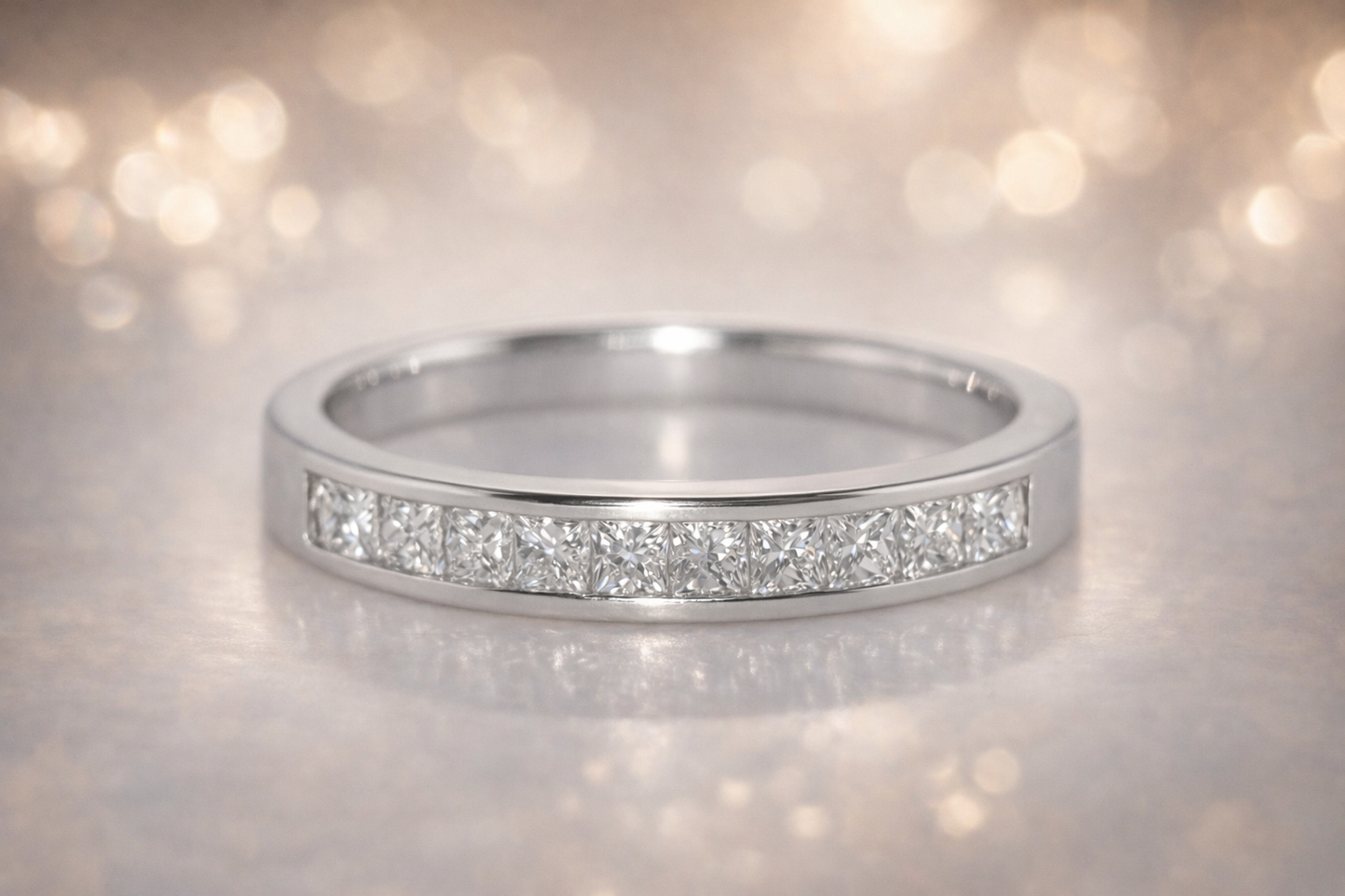18CT WHITE GOLD DIAMOND CHANNEL SET RING.