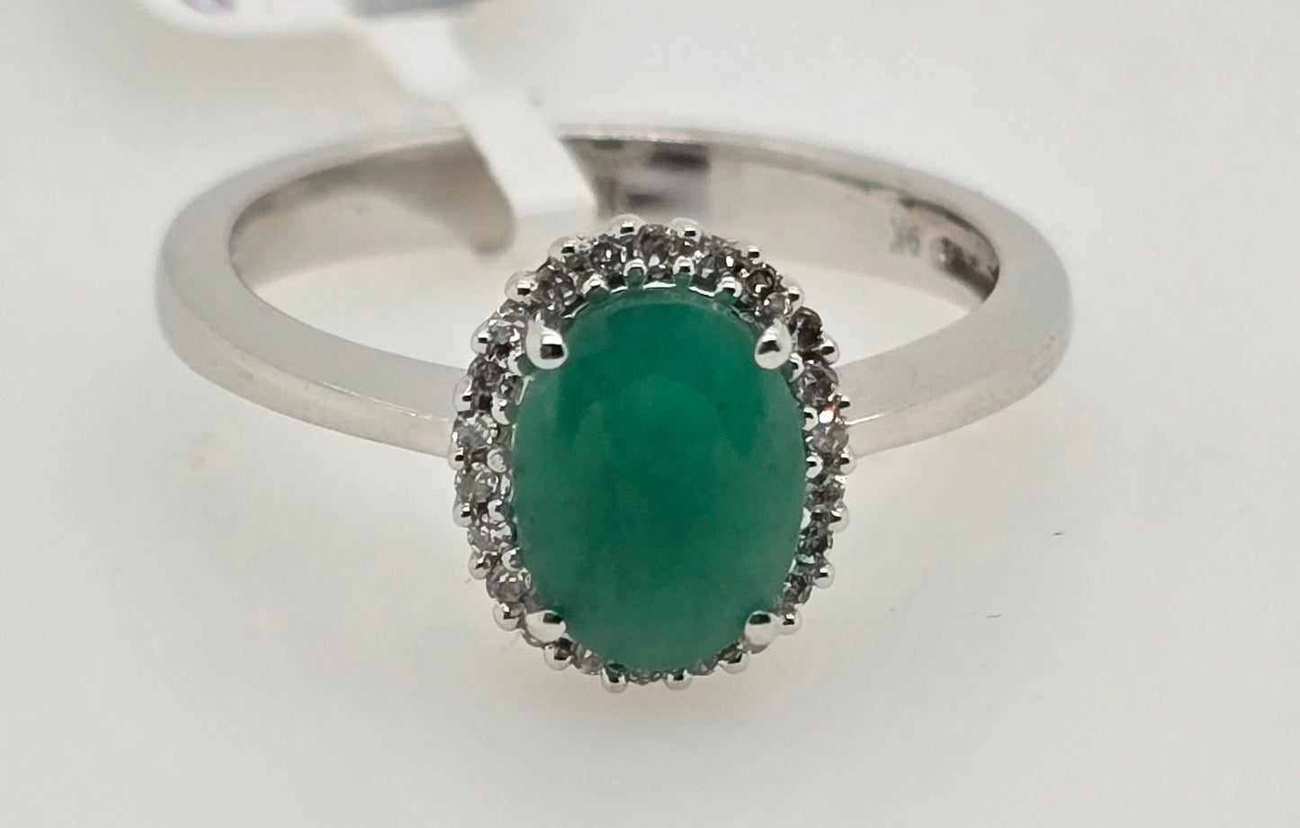 9CT WHITE GOLD OVAL EMERALD AND DIAMOND RING.