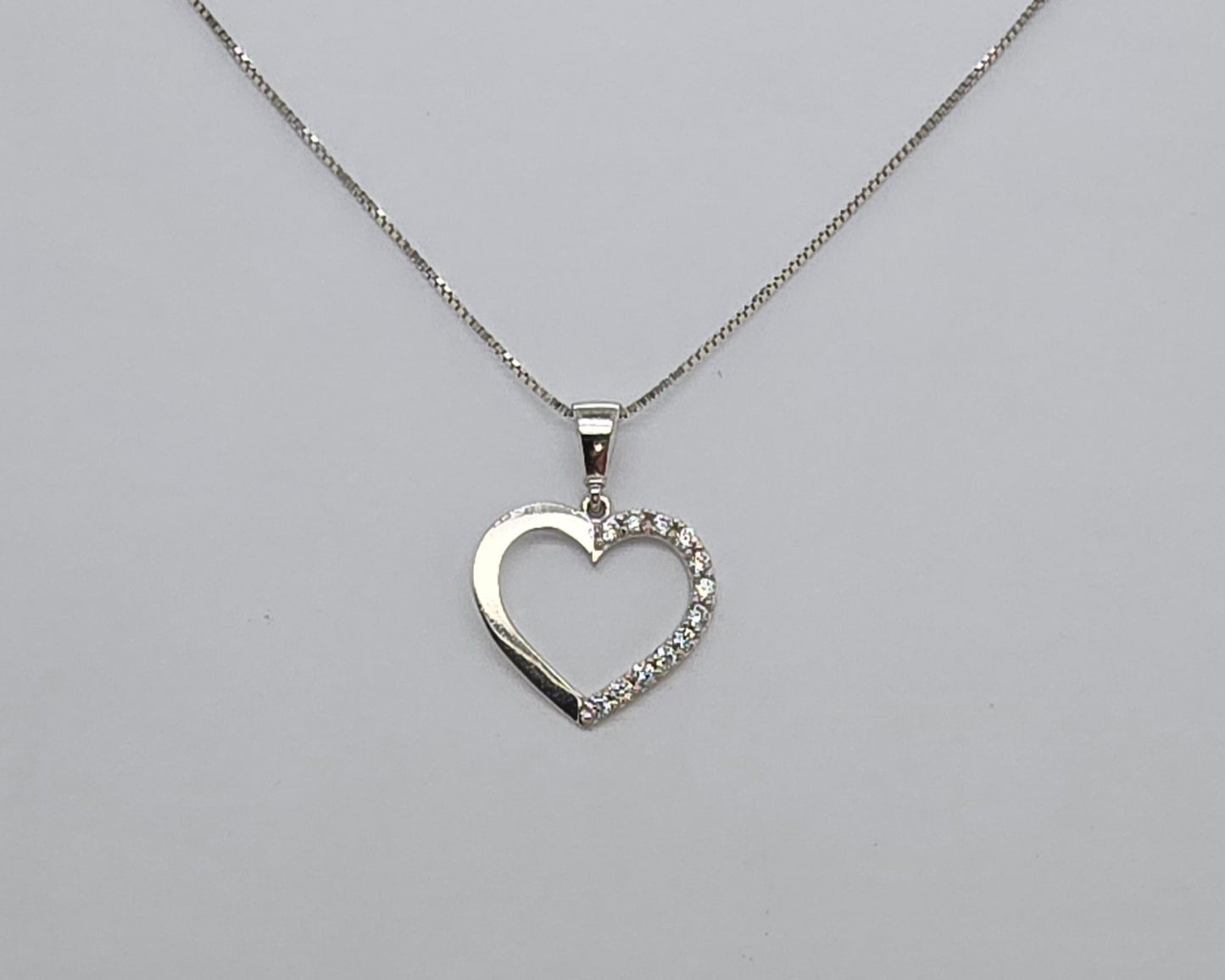 9CT WHITE GOLD CUBIC ZIRCONIA OPEN HEART PENDANT.