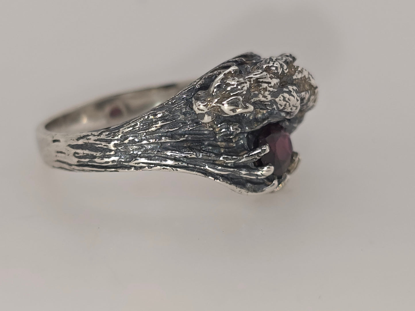 STERLING SILVER CLAW SET OVAL GARNET RING WITH A WILD CAT DESIGN.