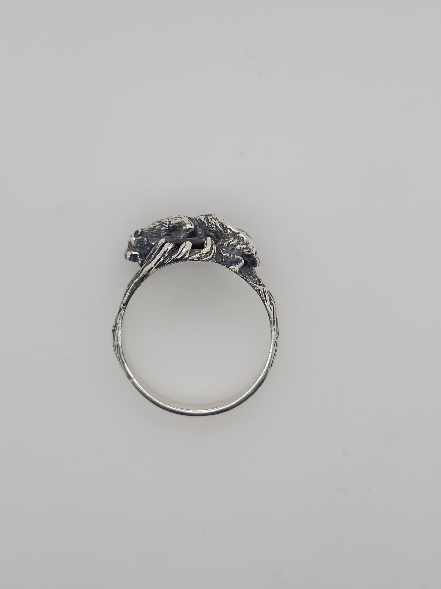 STERLING SILVER CLAW SET OVAL GARNET RING WITH A WILD CAT DESIGN.