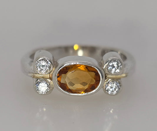 STERLING SILVER BEZEL SET CITRINE AND CUBIB ZIRCONIA RING.