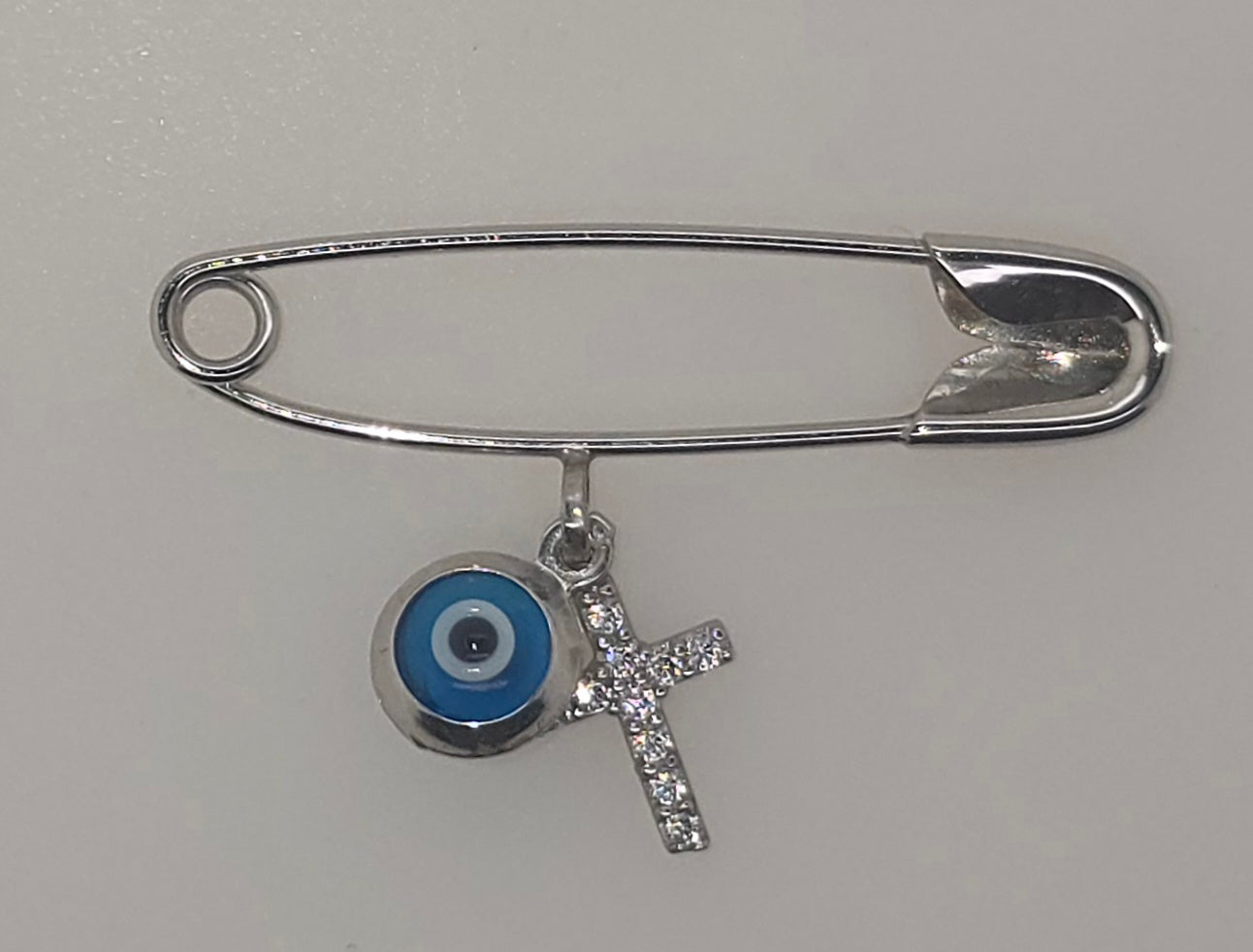 9CT WHITE GOLD IMPORTED BABY PIN WITH EVIL EYE AND CUBIC ZIRCONIA CROSS.