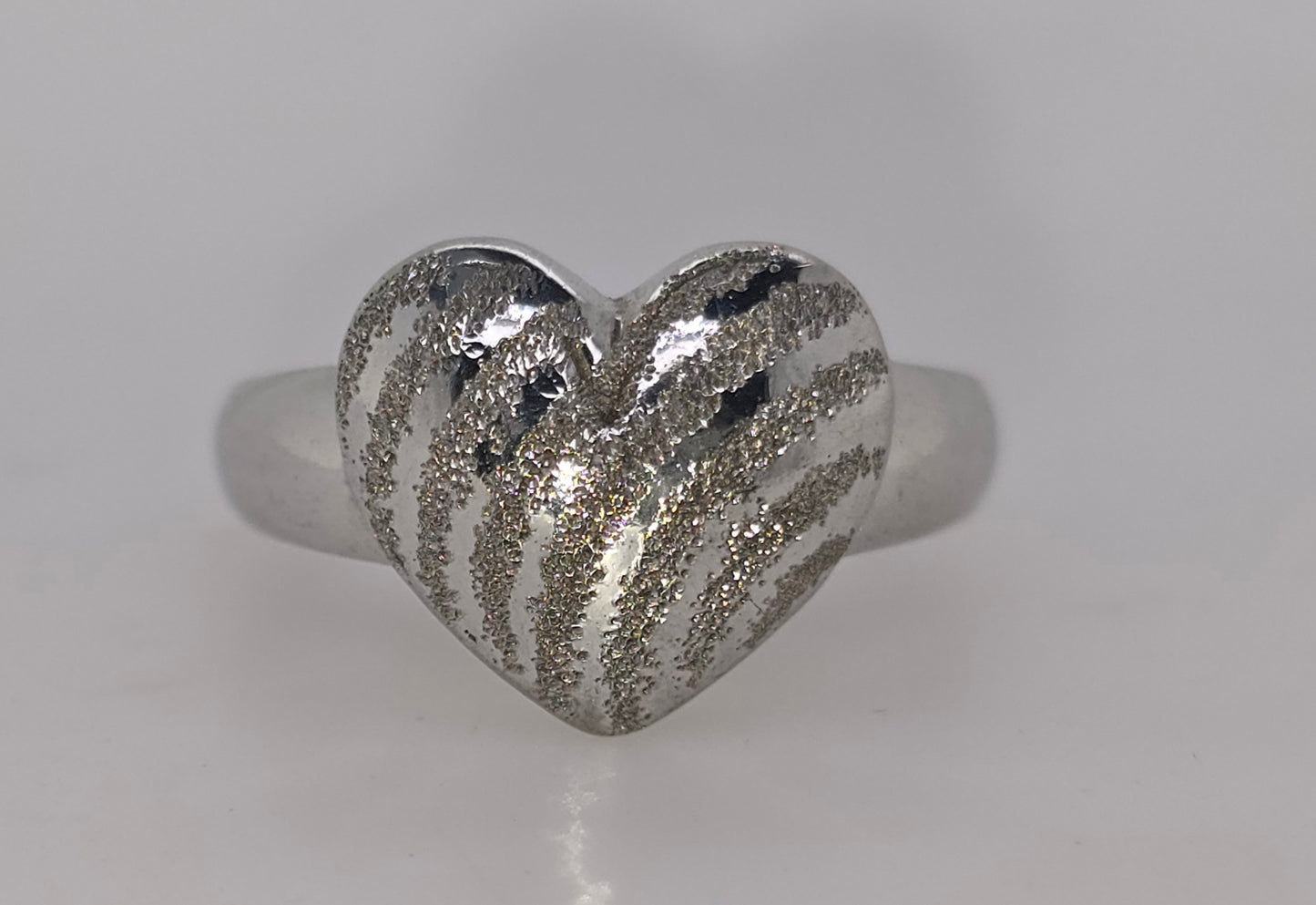 9CT WHITE GOLD 12MM PUFF HEART RING WITH DETAIL FINISH.
