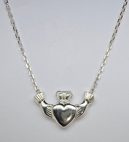 STERLING SILVER SOLID CLADDAGH PENDANT WITH ATTACHED CABLE CHAIN.