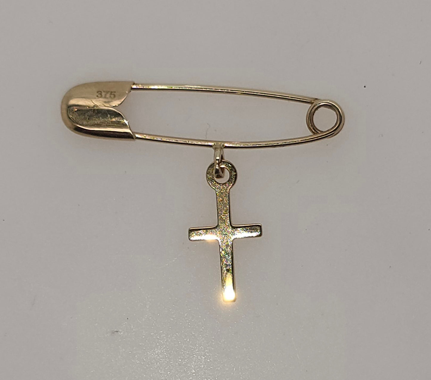 9CT YELLOW GOLD IMPORTED SAFETY PIN WITH CROSS CHARM.