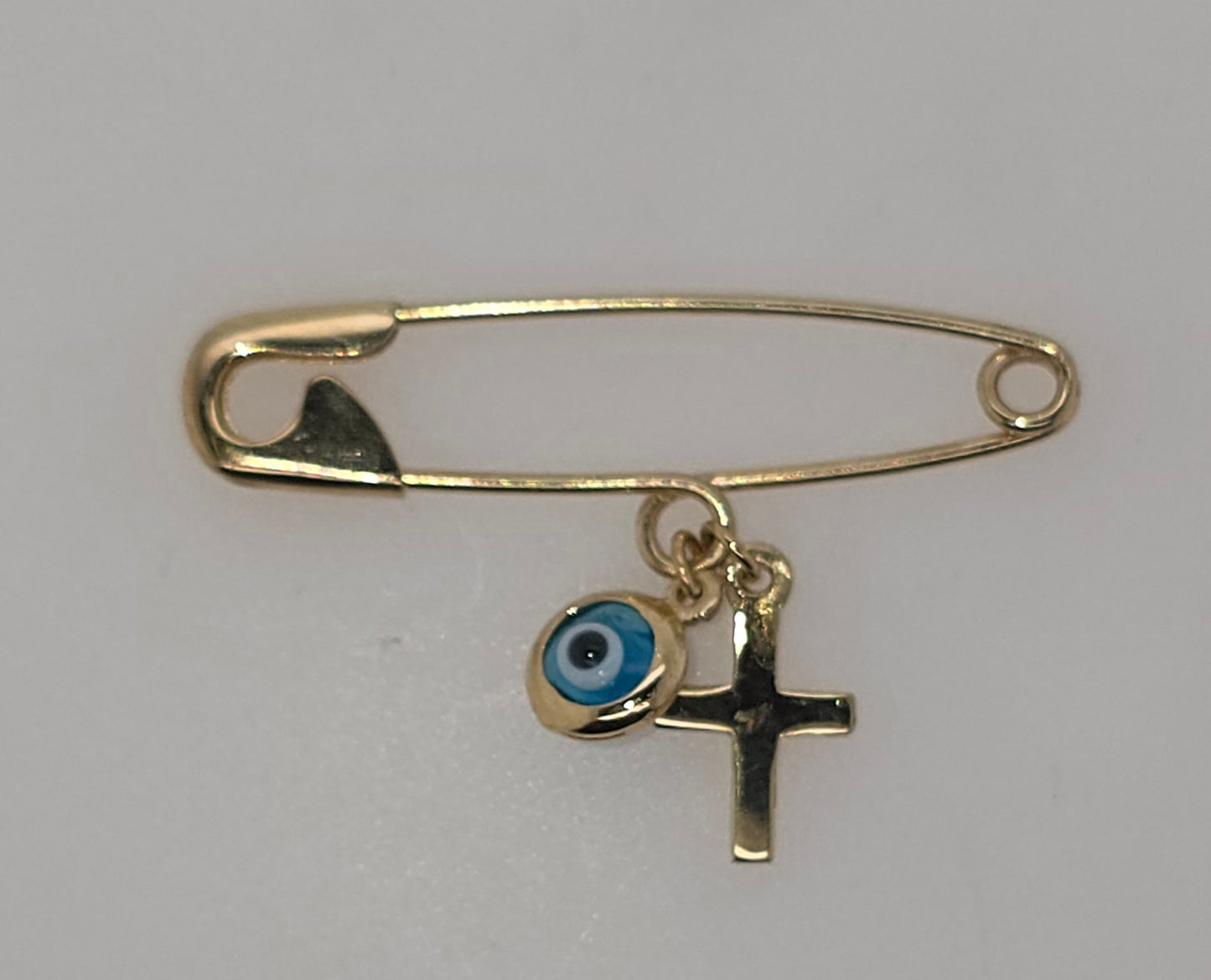 9CT YELLOW GOLD IMPORTED PIN WITH EVIL EYE AND CROSS CHARM.