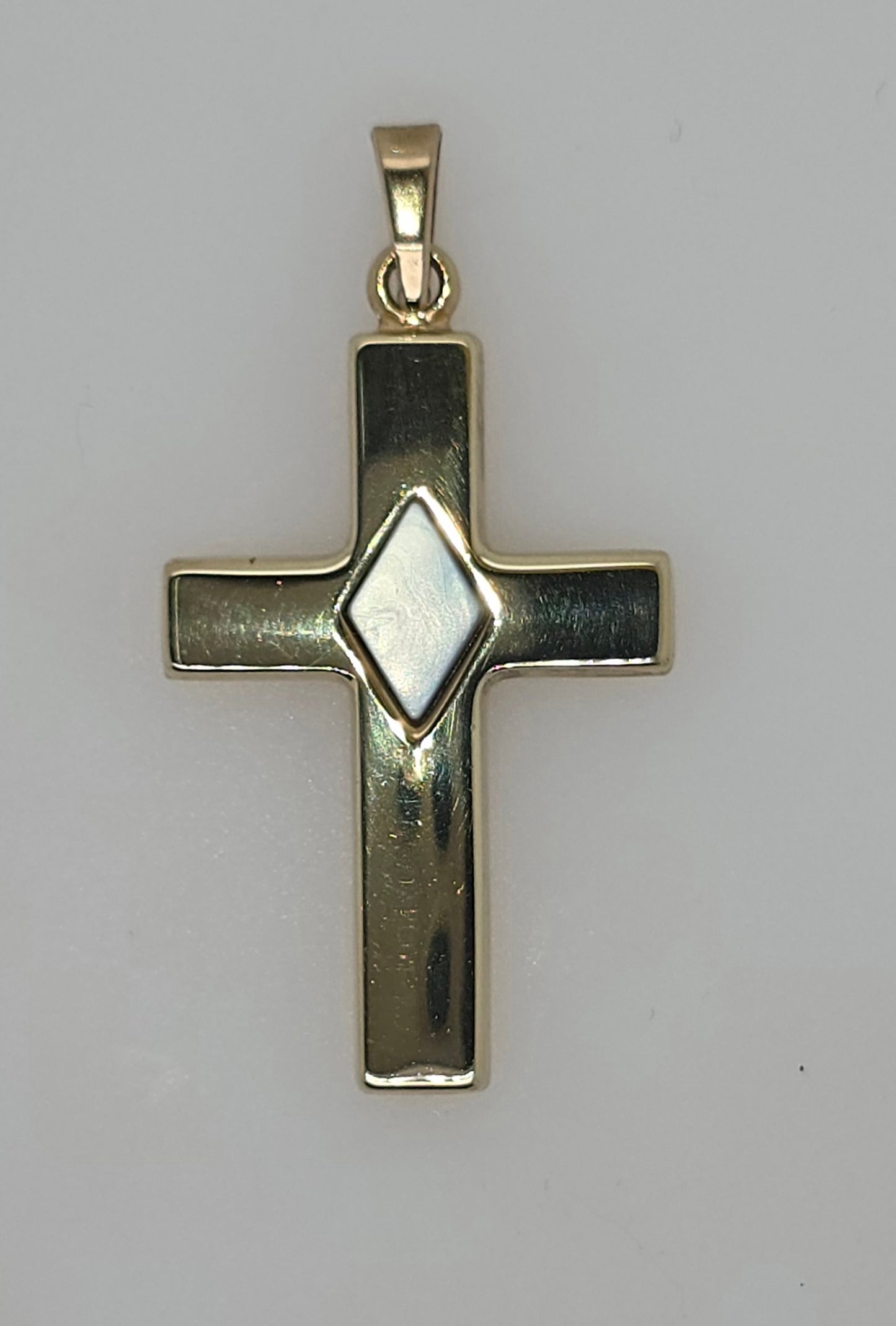 9CT YELLOW GOLD IMPORTED CROSS PENDANT WITH MOTHER OF PEARL CENTER.