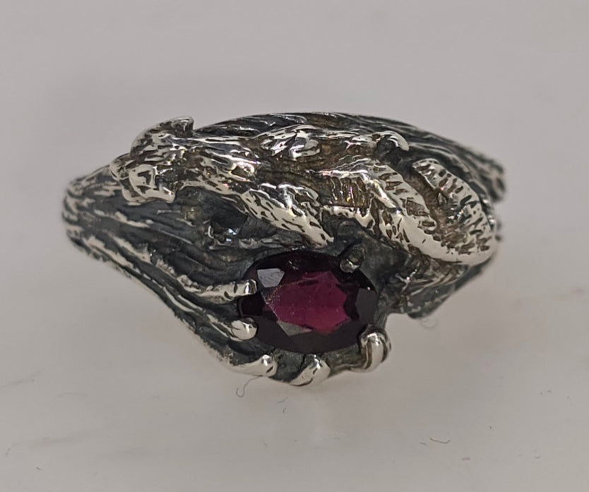 STERLING SILVER CLAW SET 7 X 5MM CUT OVAL GARNET RING.