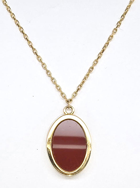 9CT YELLOW GOLD BEZEL SET OVAL CARNELIAN PENDANT WITH CHAIN.
