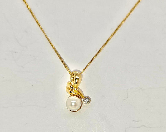 9CT YELLOW GOLD DIAMOND AND FRESHWATER PEARL PENDANT.