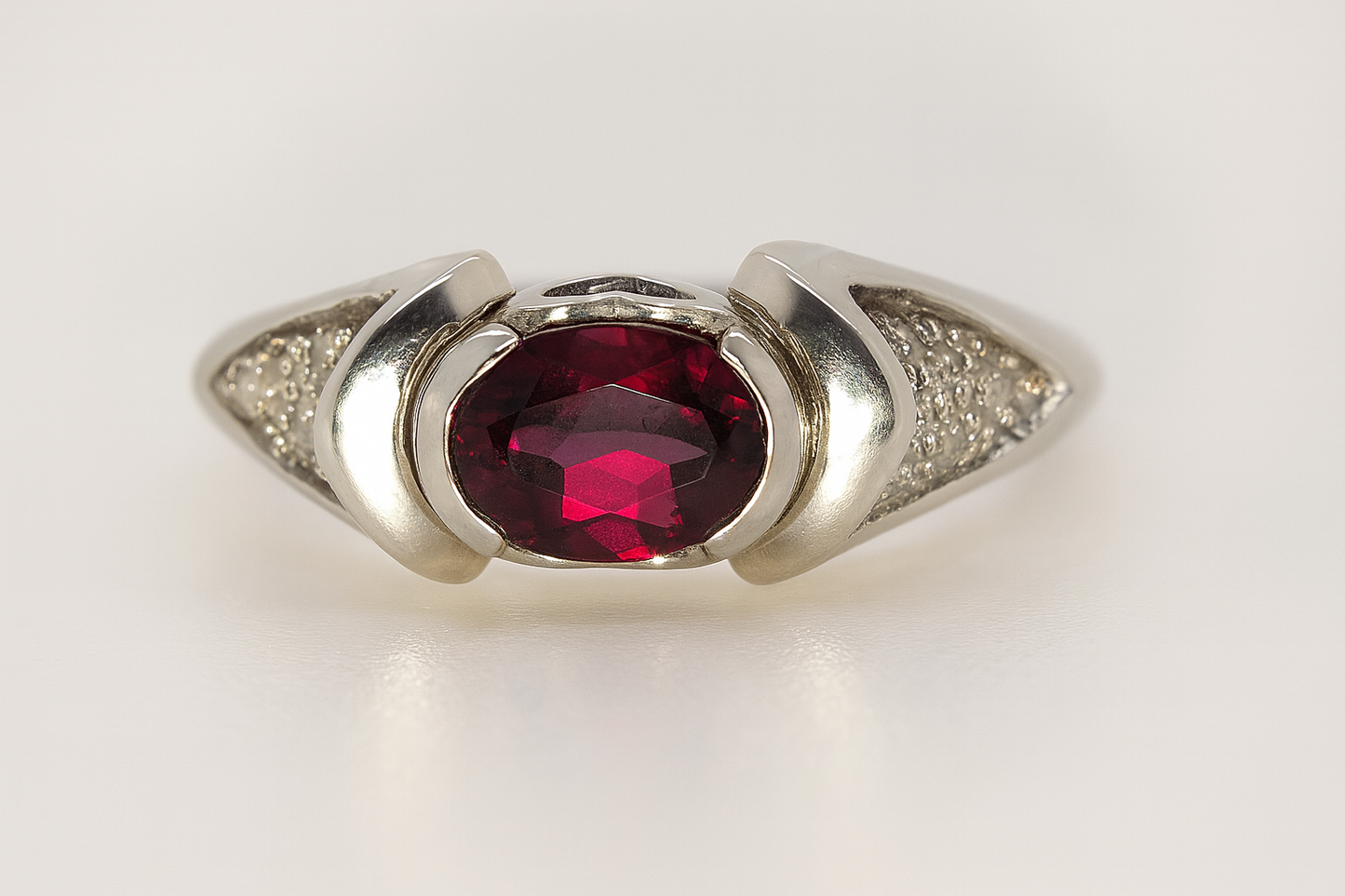STERLING SILVER SEMI BEZEL SET 7 X 5 OVAL GARNET RING.