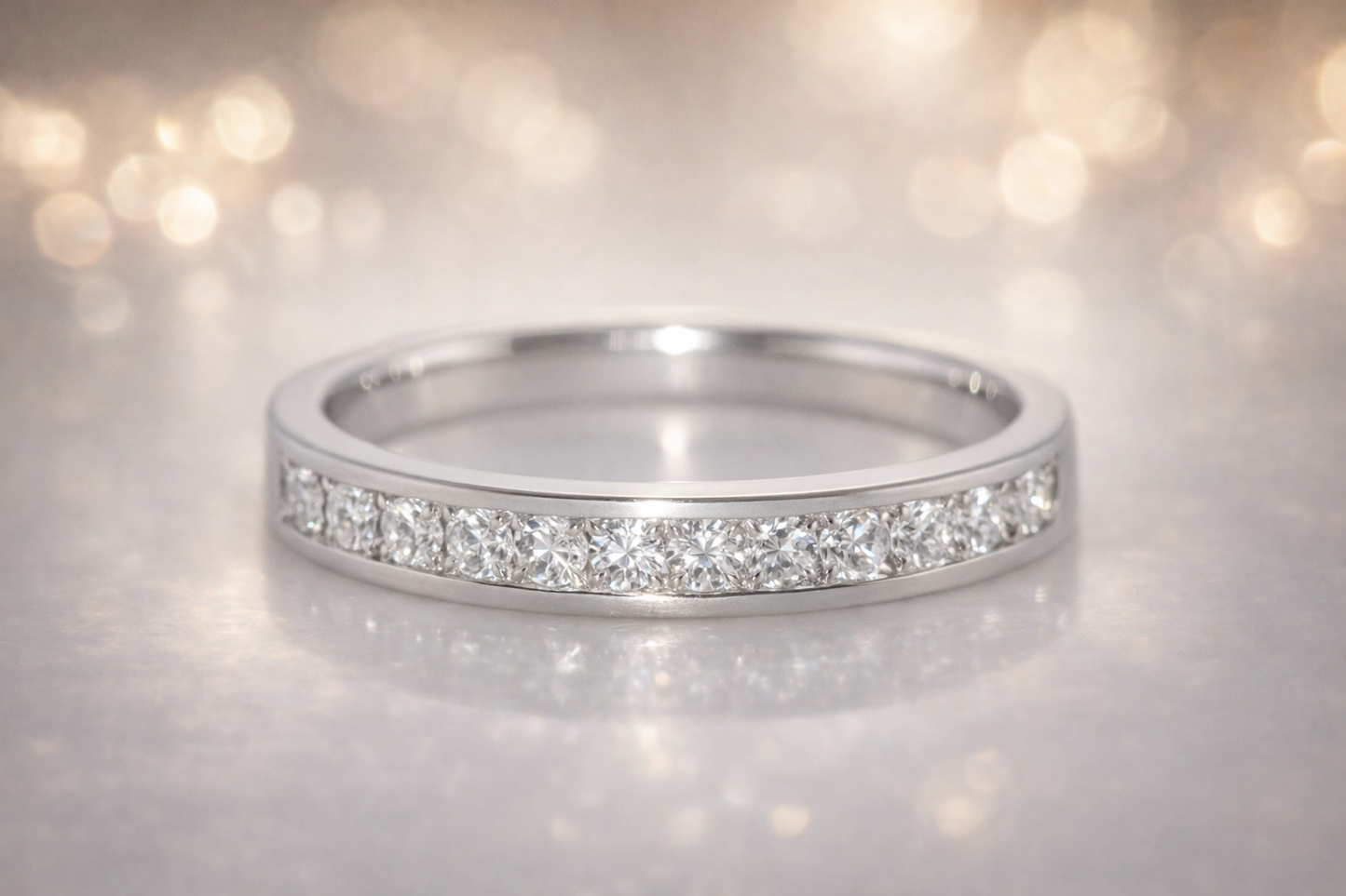 18CT WHITE GOLD CHANNEL SET DIAMOND RING.