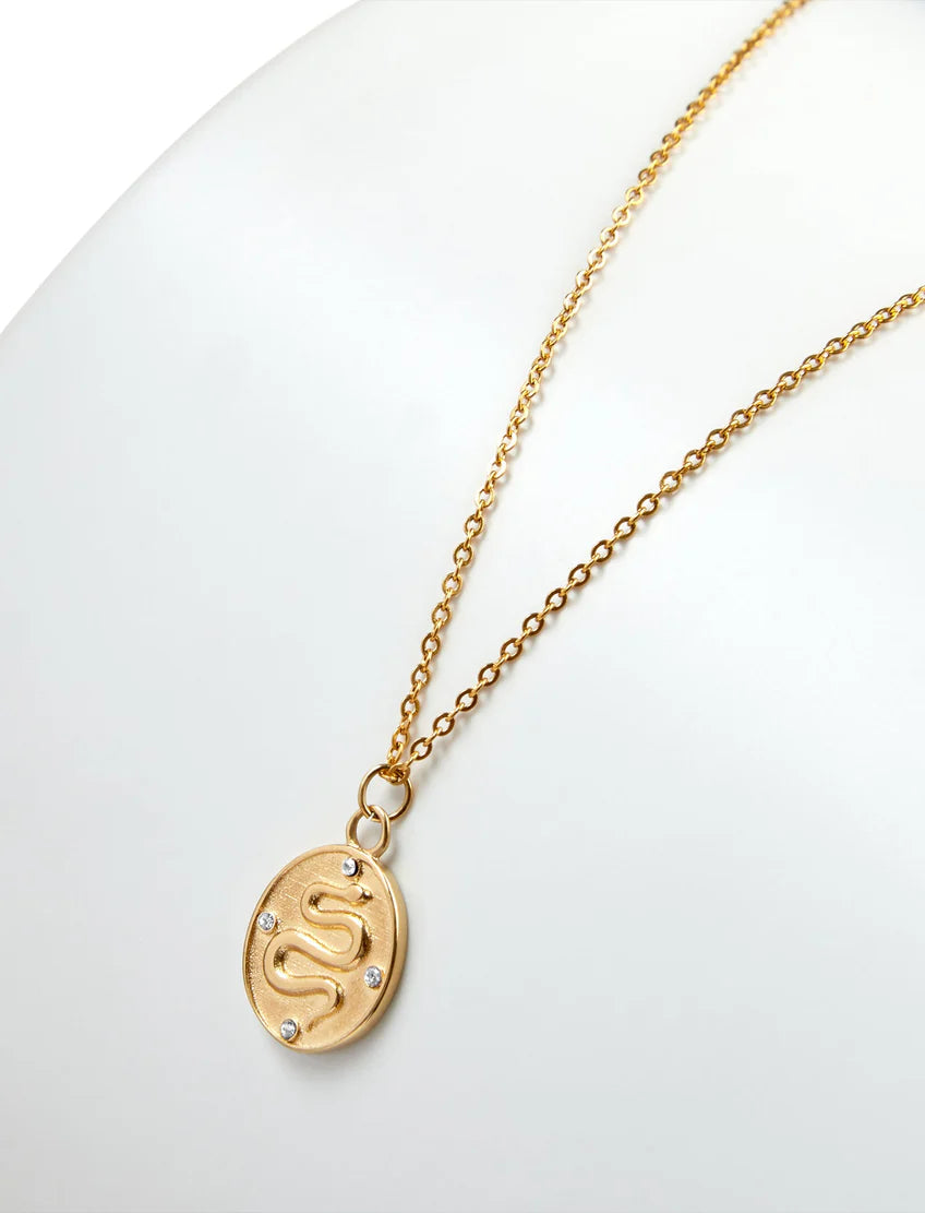 PASTICHE STAINLESS STEEL GOLD PLATED ERIS NECKLACE WITH SNAKE AND CUBIC ZIRCONIA OVAL PENDANT